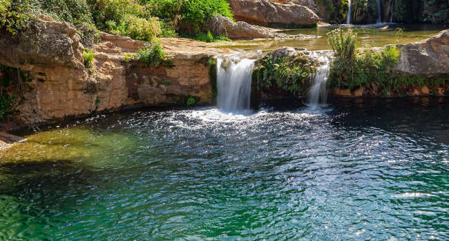 Photo of a river fed by a waterfall